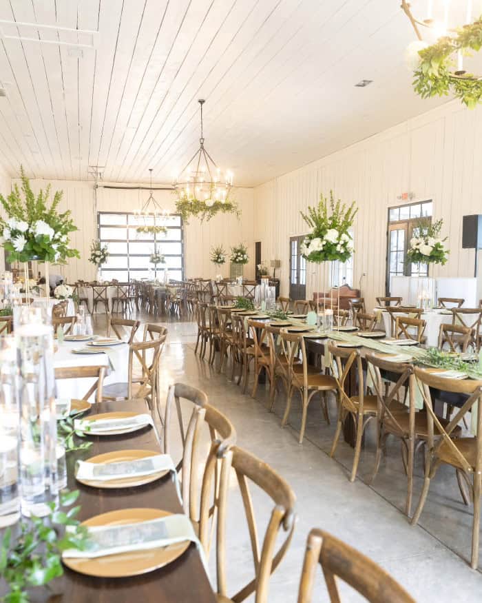 Beautifully decorated event space with wooden tables and floral centerpieces.