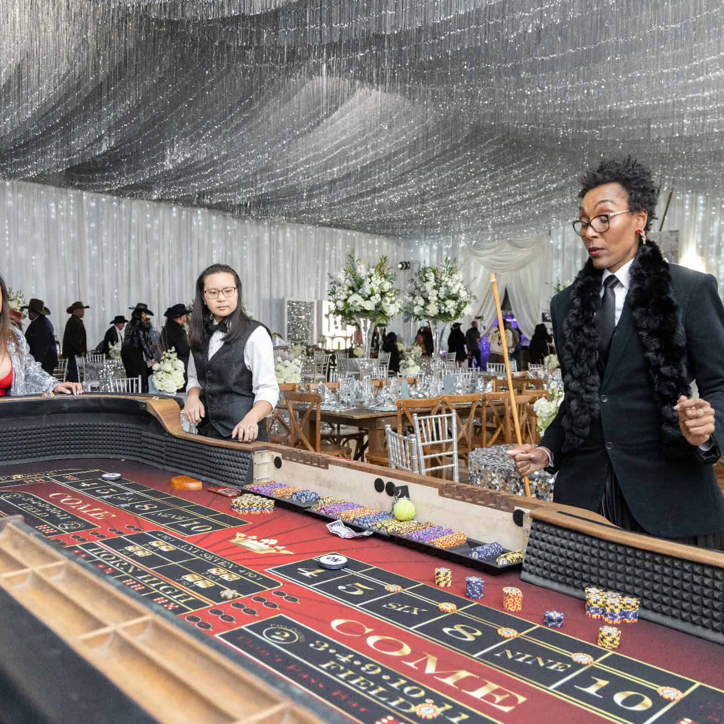 Woman in black blazer playing roulette at casino event.