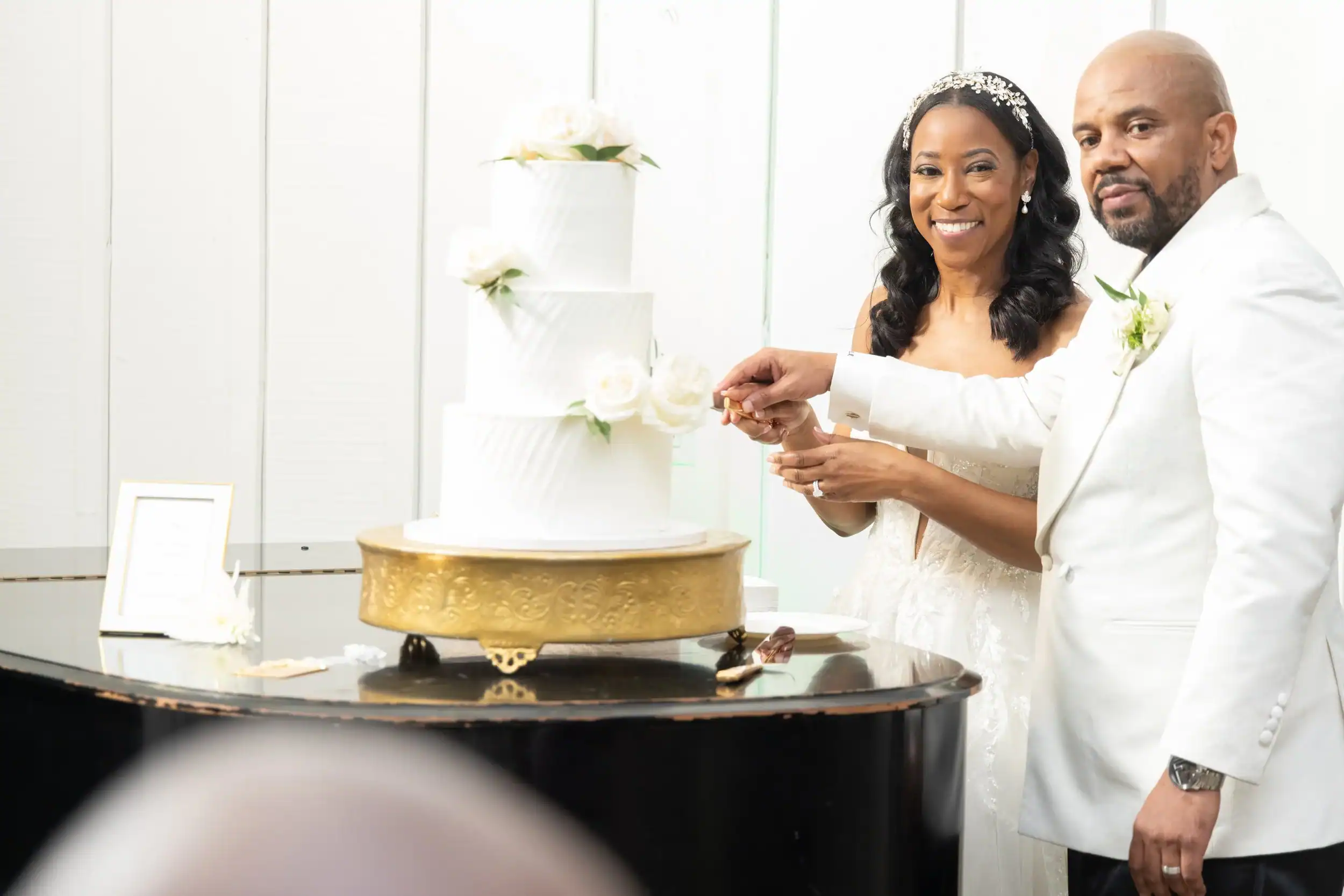 Happy bride and groom cutting wedding cake at Angela J. White Consulting event.