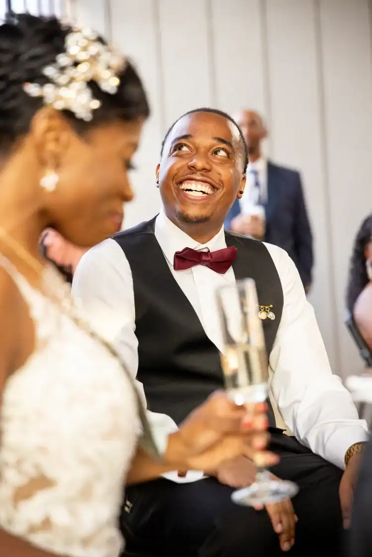Happy man in tuxedo at Angela J. White Consulting event.