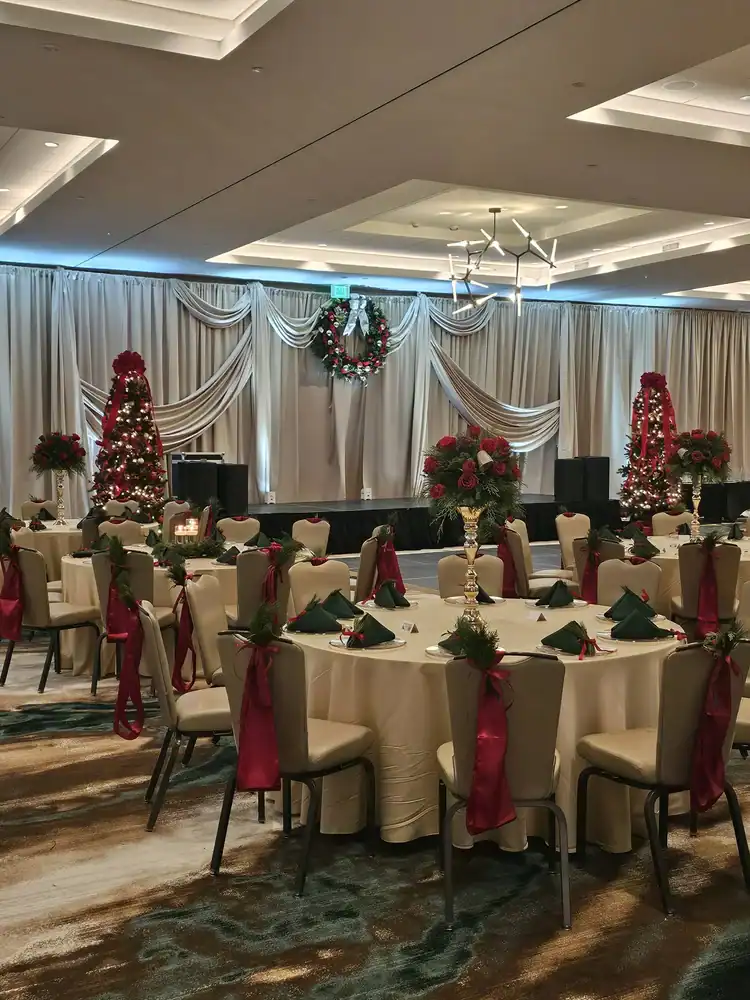 Festive banquet hall decorated for Christmas with wreaths and poinsettias.