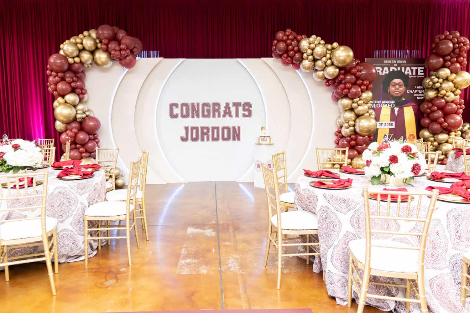 Elegant event setup with balloons and decorated tables for Jordon celebration.