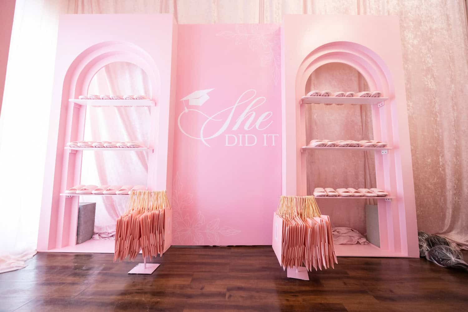Elegant pink-themed event display with shelves and seating for Angela J. White Consulting.
