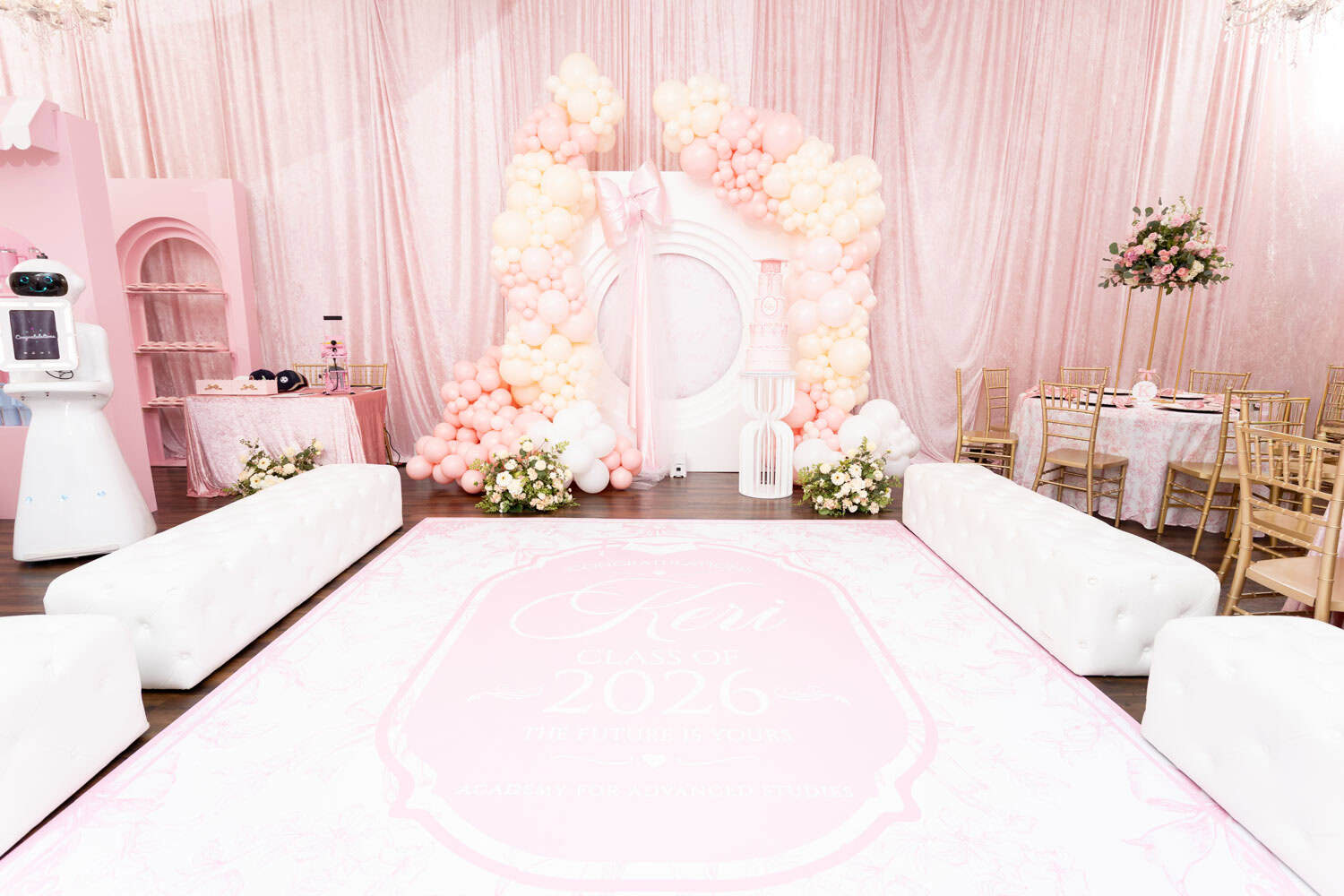 Beautiful pink and white event decor with balloons and floral arrangements.