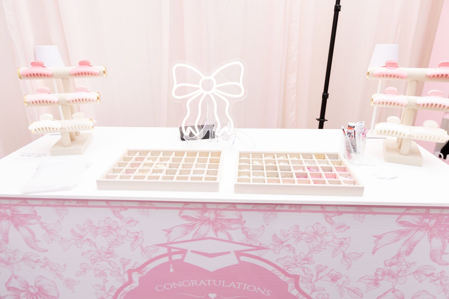 Elegant event display with pastel decor and makeup samples for Angela J. White Consulting.