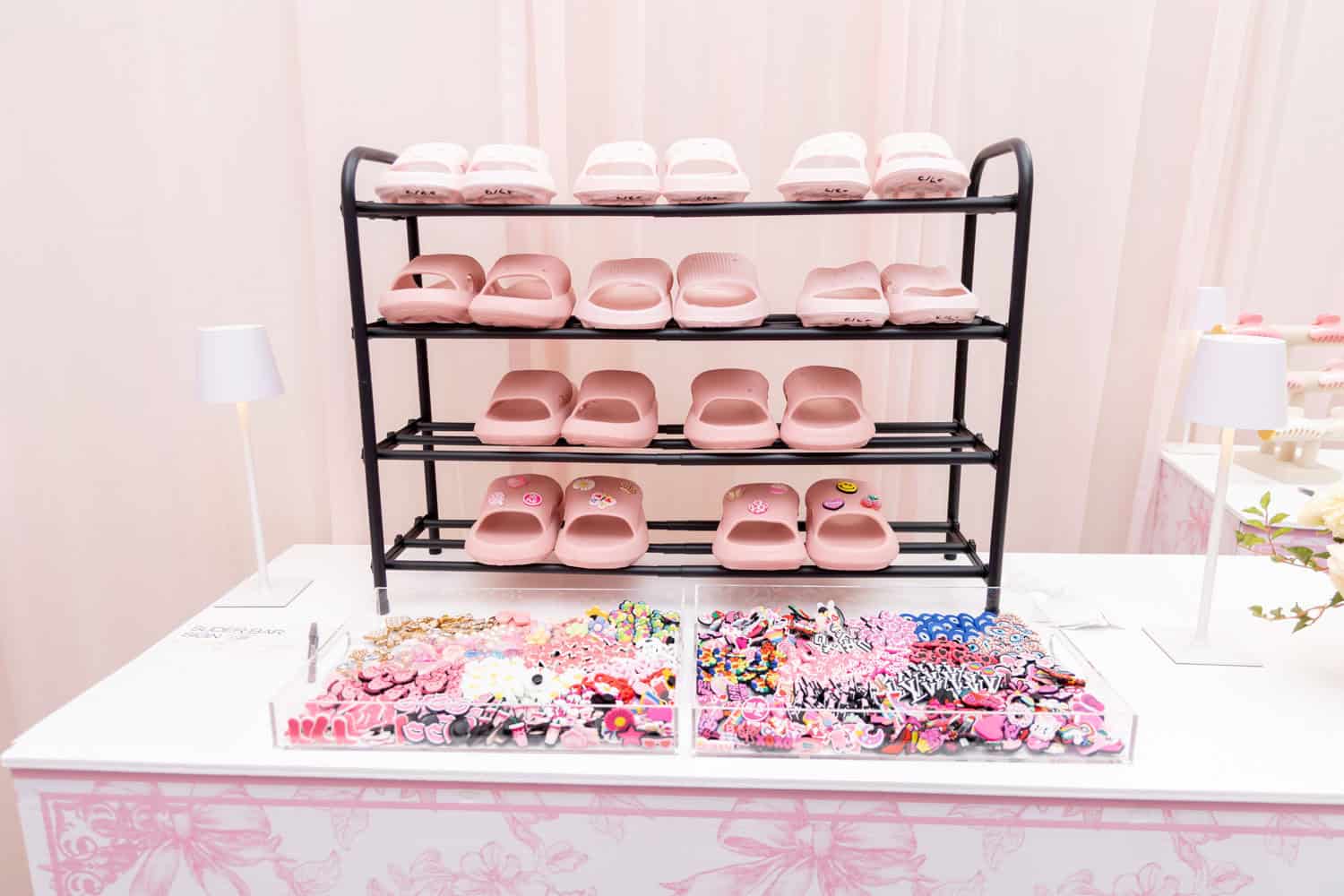 Display of pink slippers on black metal rack at Angela J. White Consulting.