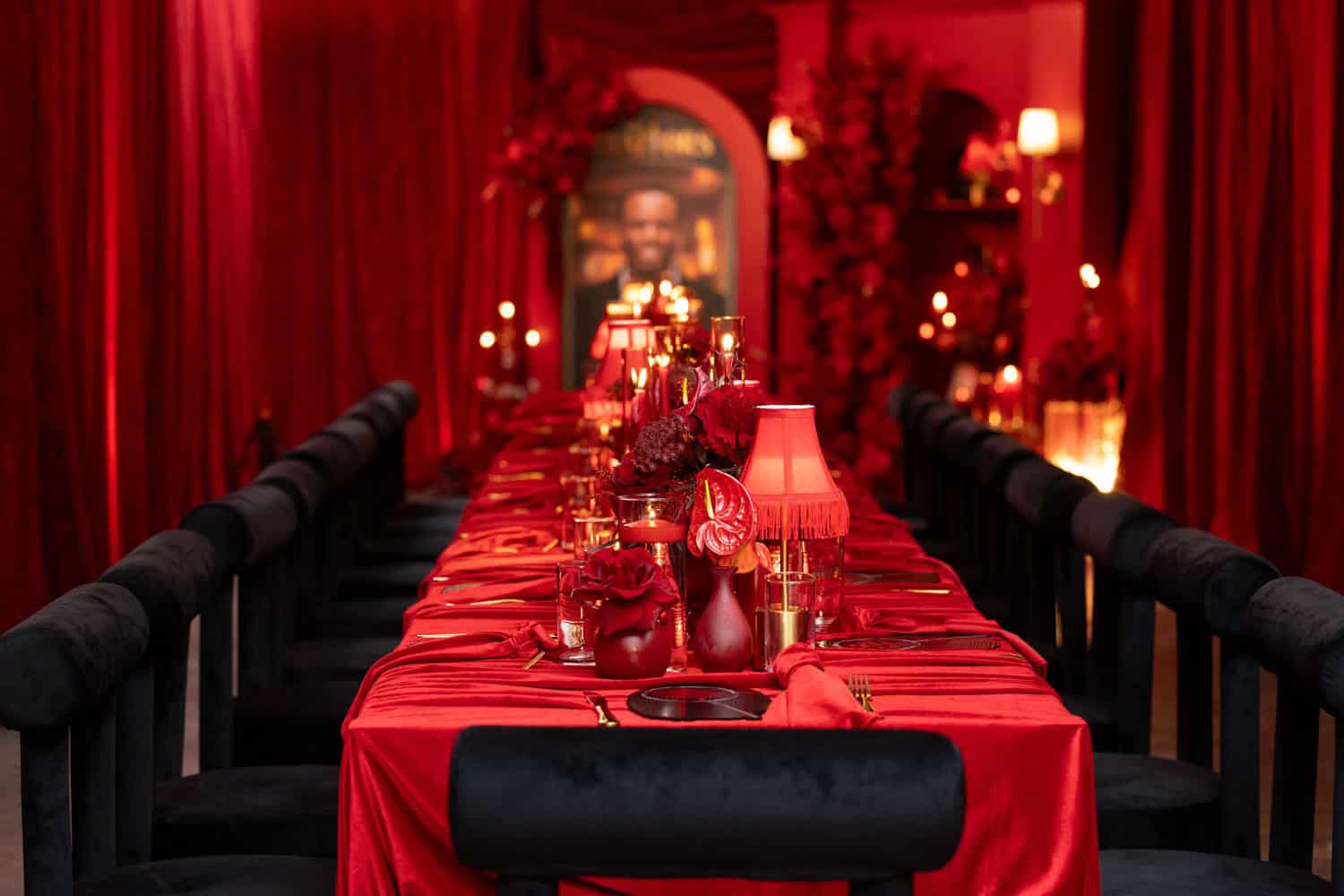 Luxurious red-themed dining room with candles and floral arrangements.