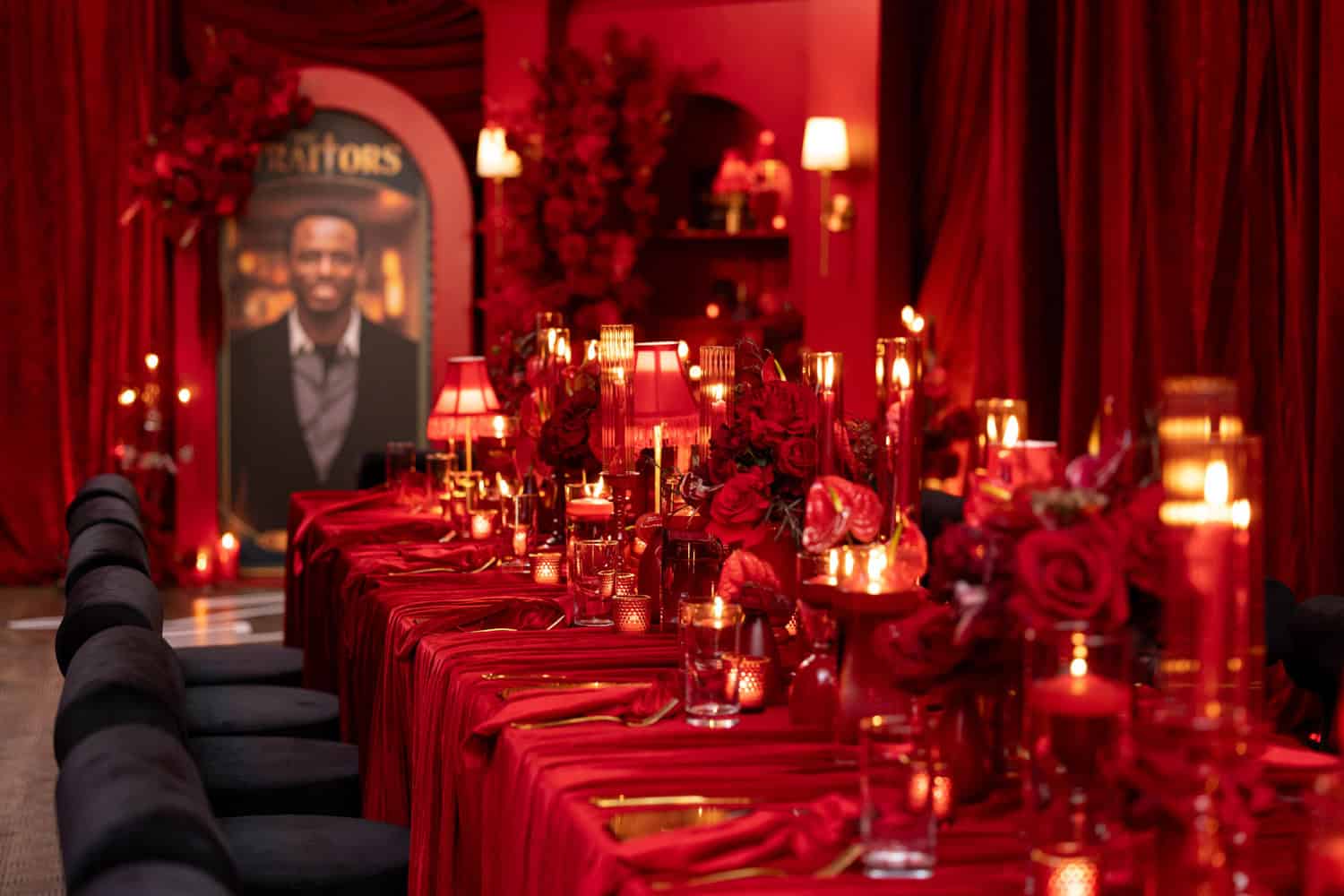 Luxurious red event table with roses and candles for a sophisticated gathering.