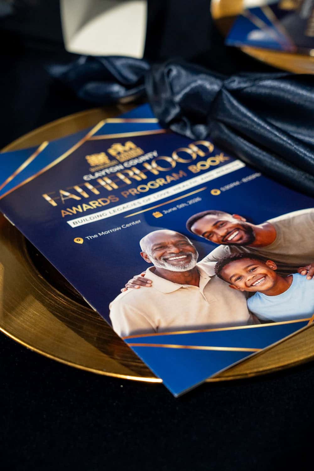 Award ceremony program booklet with smiling family photo and gold tray.