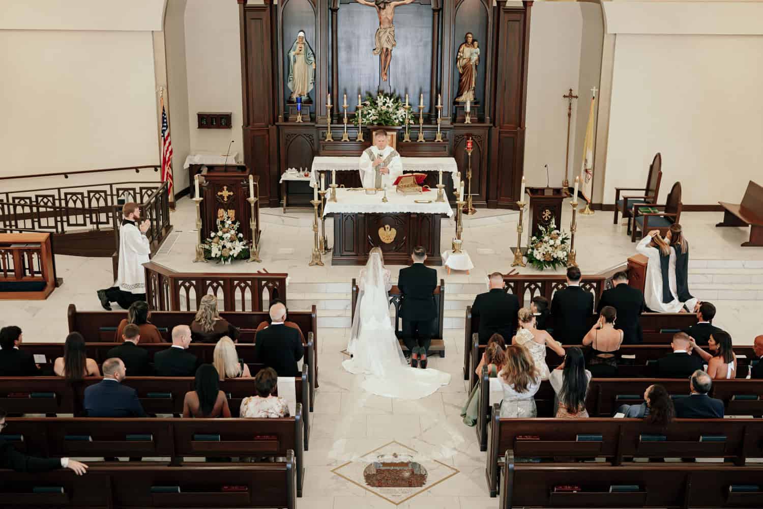 Wedding ceremony taking place inside a church with guests and clergy.