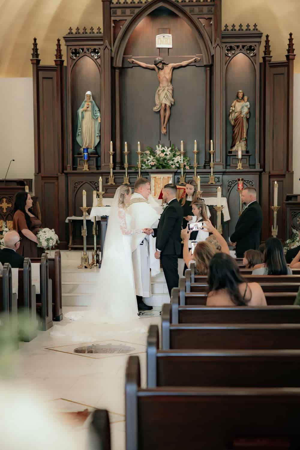 Bride and groom exchanging vows at church altar during wedding ceremony.