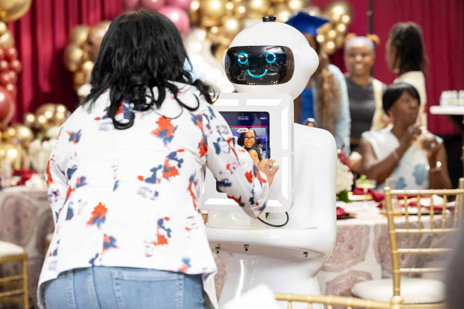 A woman interacts with a friendly robot at a social gathering.