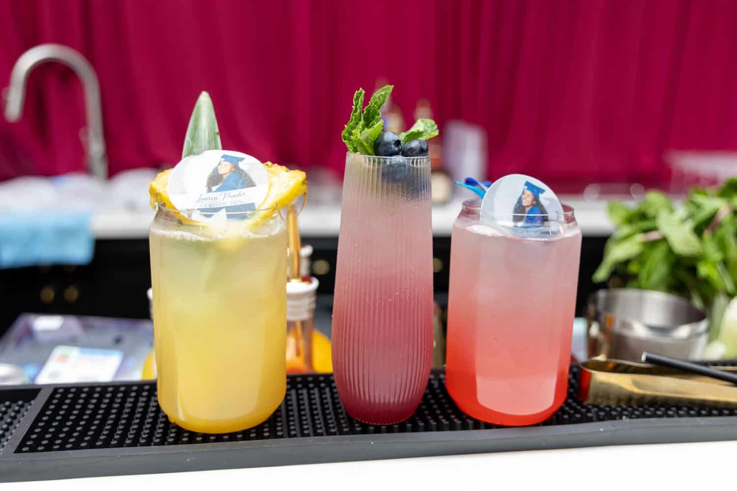 Three vibrant cocktails with garnishes on a bar counter for Angela J. White Consulting.
